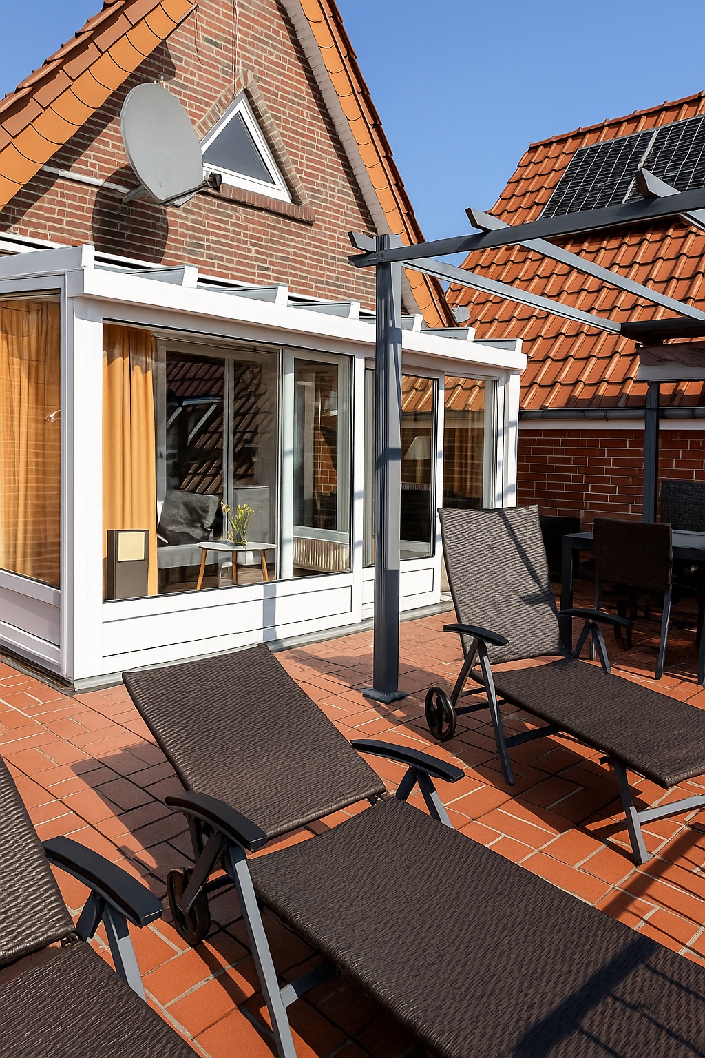 Terrasse mit Liegen und Blick auf den Wintergarten